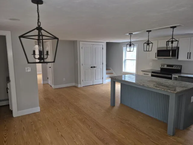 a view of a kitchen with a sink wooden floor and a chandelier