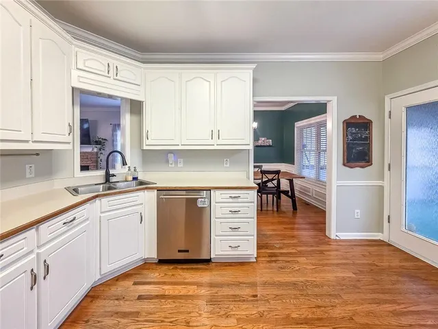 a kitchen with stainless steel appliances granite countertop a stove and white cabinets