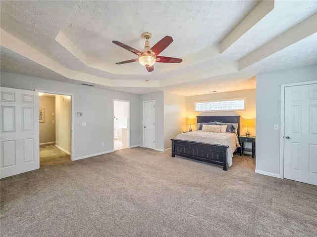 a spacious bedroom with a bed and a chandelier