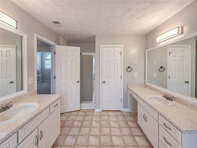 a spacious bathroom with a granite countertop sink a toilet a mirror and shower