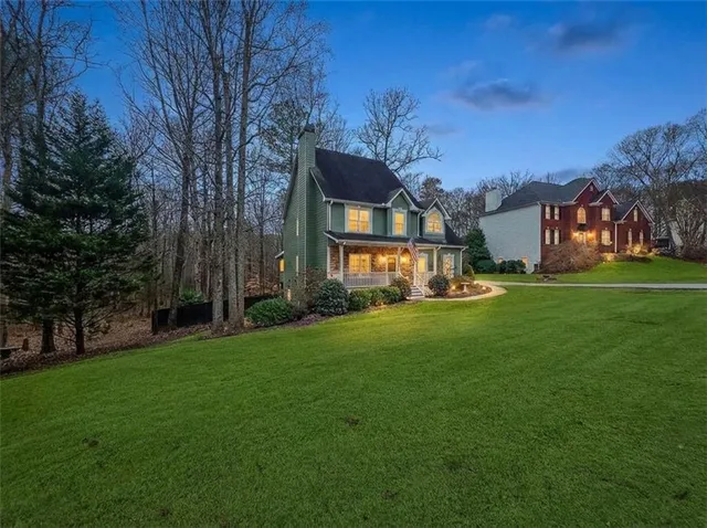 a view of a big house with a big yard and large trees