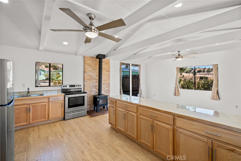 7787 Hidden Ranch Road Apple Valley, CA 92308 - Photo 16 of 36 a large kitchen with stainless steel appliances granite countertop a stove and a sink with cabinets