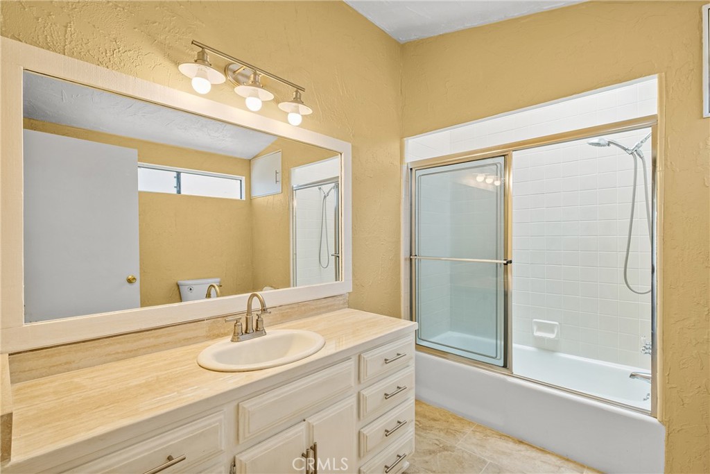 7787 Hidden Ranch Road Apple Valley, CA 92308 - Photo 17 of 36 a bathroom with a granite countertop sink mirror and a shower
