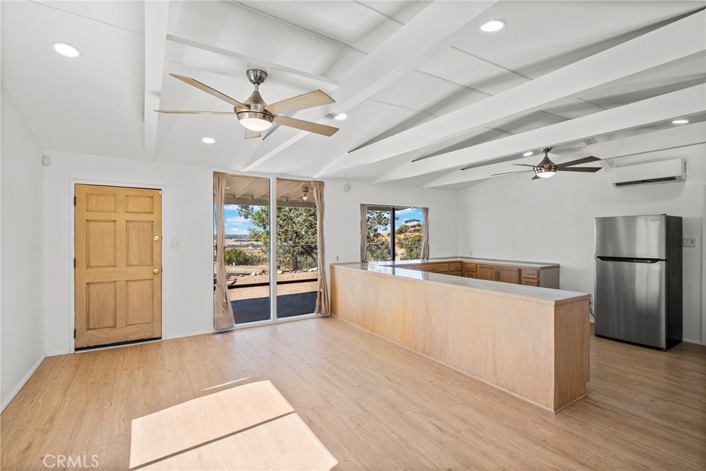 7787 Hidden Ranch Road Apple Valley, CA 92308 - Photo 9 of 36 a kitchen with stainless steel appliances a stove top oven a refrigerator cabinets and wooden floor
