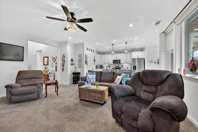 a kitchen with stainless steel appliances kitchen island granite countertop a table chairs sink and cabinets