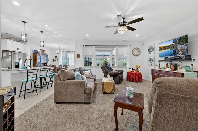 a living room with furniture kitchen area and a window