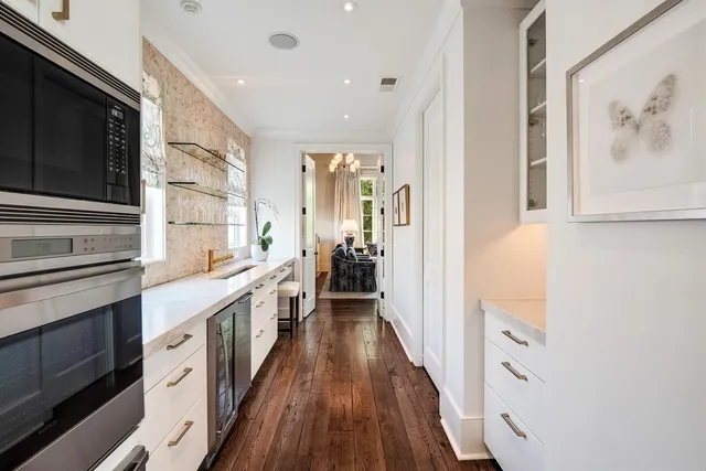 a large white kitchen with a stove top oven