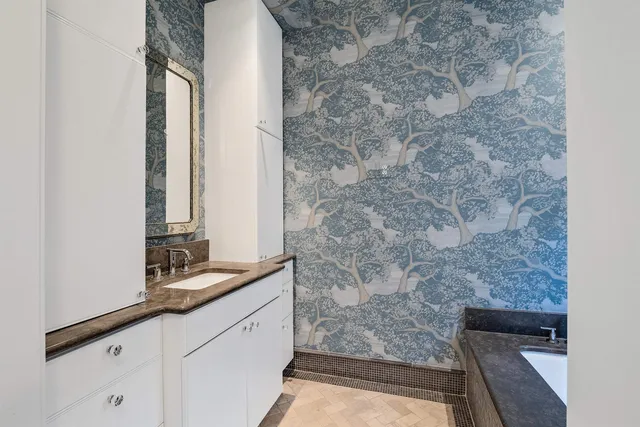 a bathroom with a granite countertop sink a mirror and shower