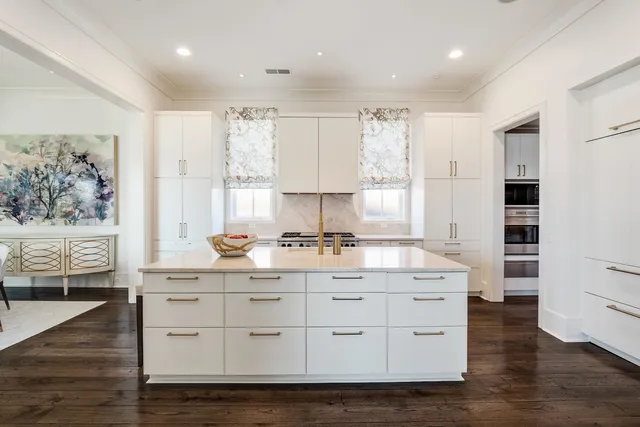 a kitchen with stainless steel appliances white cabinets and wooden floors