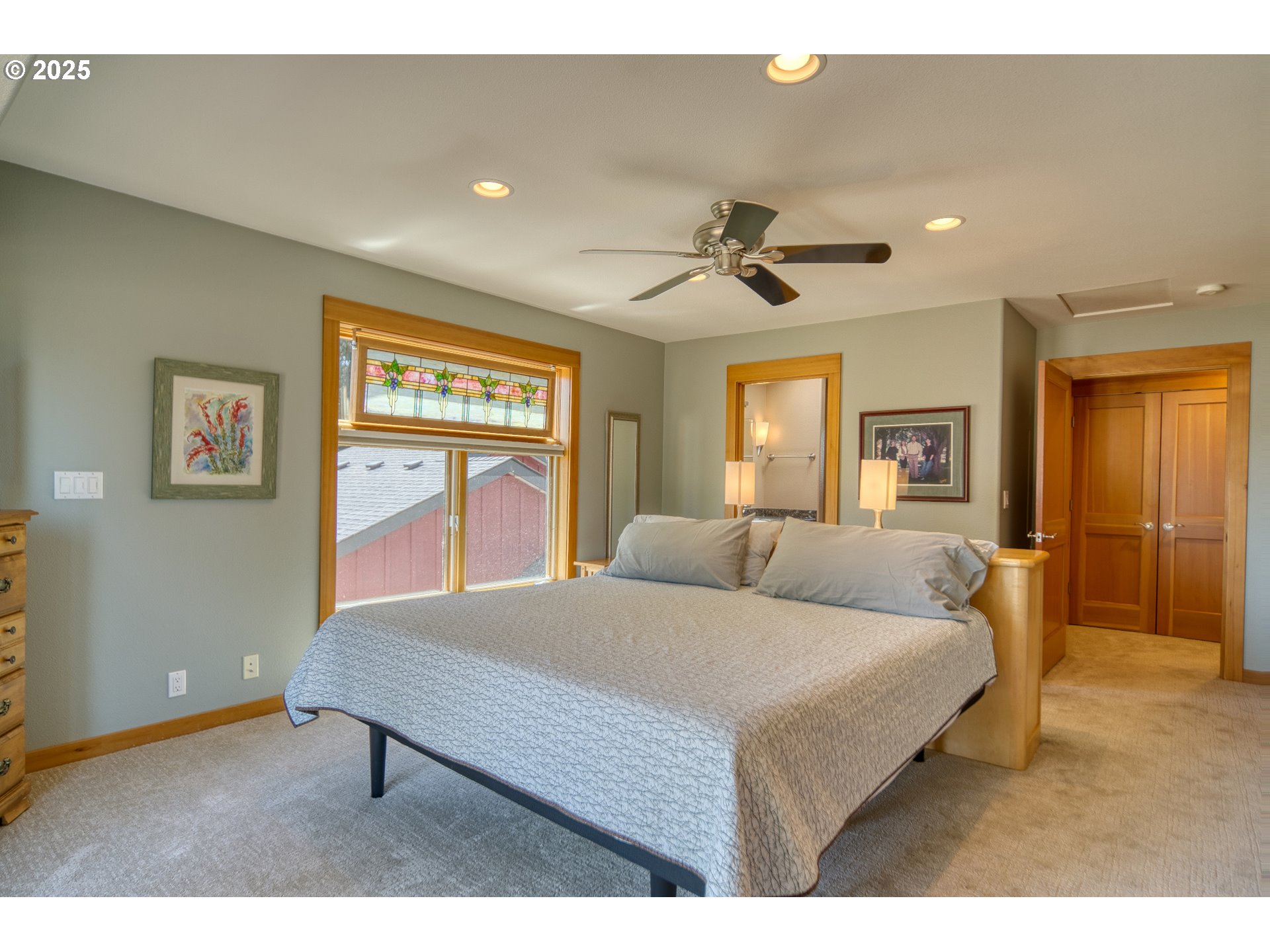 22732 Northwest Gillihan Road Portland, OR 97231 - Photo 25 of 48 a bed room with a bed and a chandelier