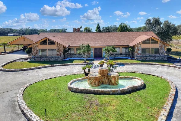 a view of a house with swimming pool and a yard