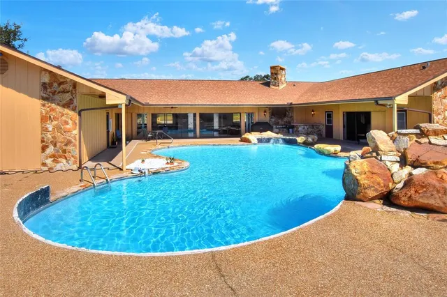 a bedroom with a bed a chandelier and a flat screen television