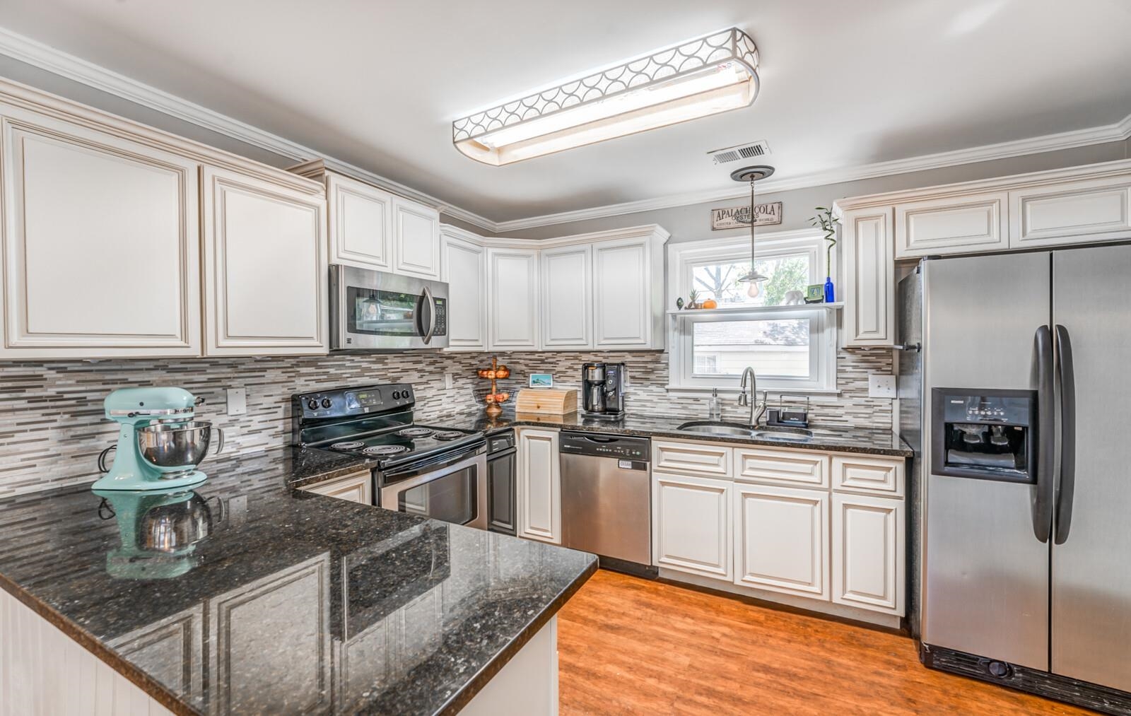 453 Fleda Road Memphis, TN 38120 - Photo 14 of 31 a kitchen with stainless steel appliances granite countertop a sink stove and refrigerator