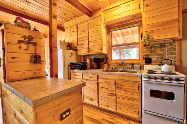 a kitchen with kitchen island a stove a sink and a window