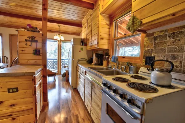 a kitchen with a stove and a wooden floor
