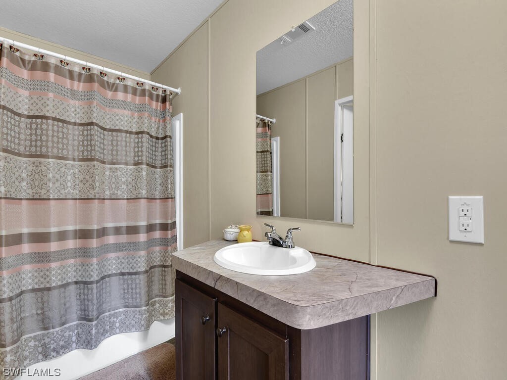 1183 Summerall Road LaBelle, FL 33935 - Photo 14 of 28 a bathroom with a sink shower and a mirror