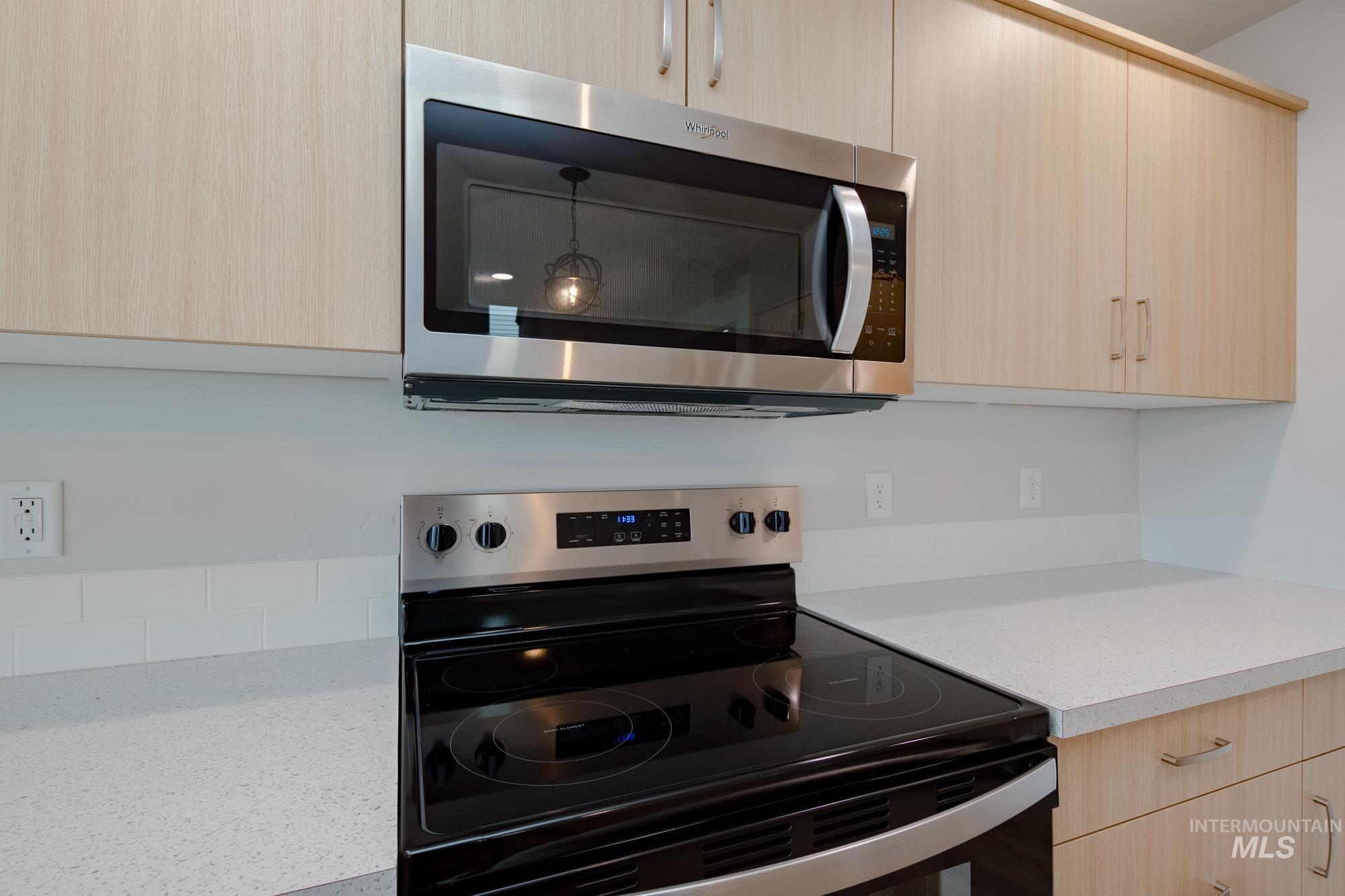 2486 West Fallon Loop Nampa, ID 83651 - Photo 11 of 18 Kitchen with light brown cabinetry, stainless steel appliances, modern cabinets, and light stone counters
