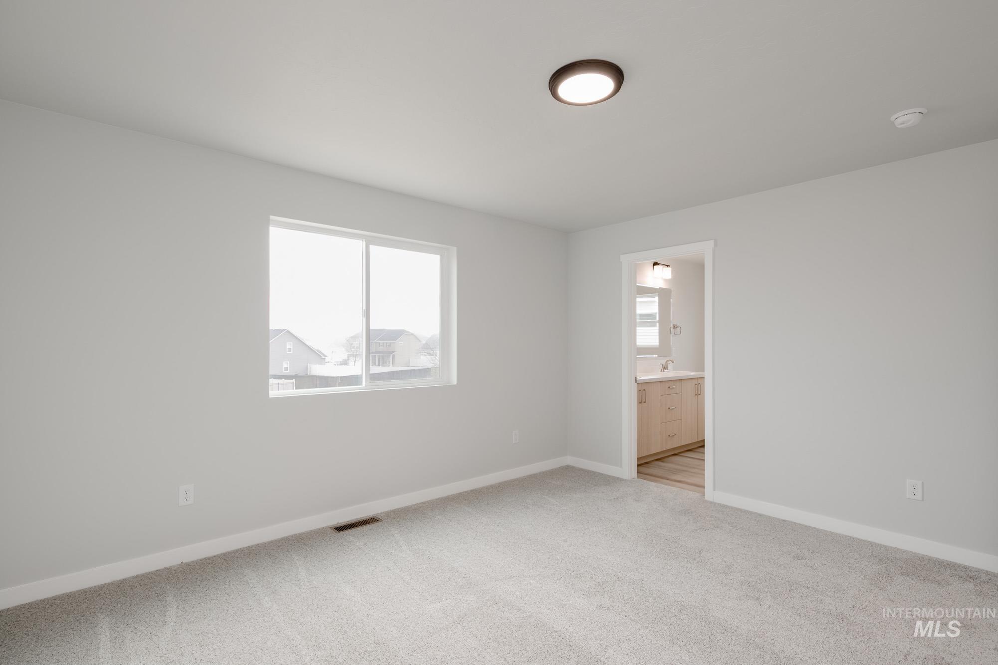 2486 West Fallon Loop Nampa, ID 83651 - Photo 12 of 18 Unfurnished bedroom with light colored carpet and connected bathroom