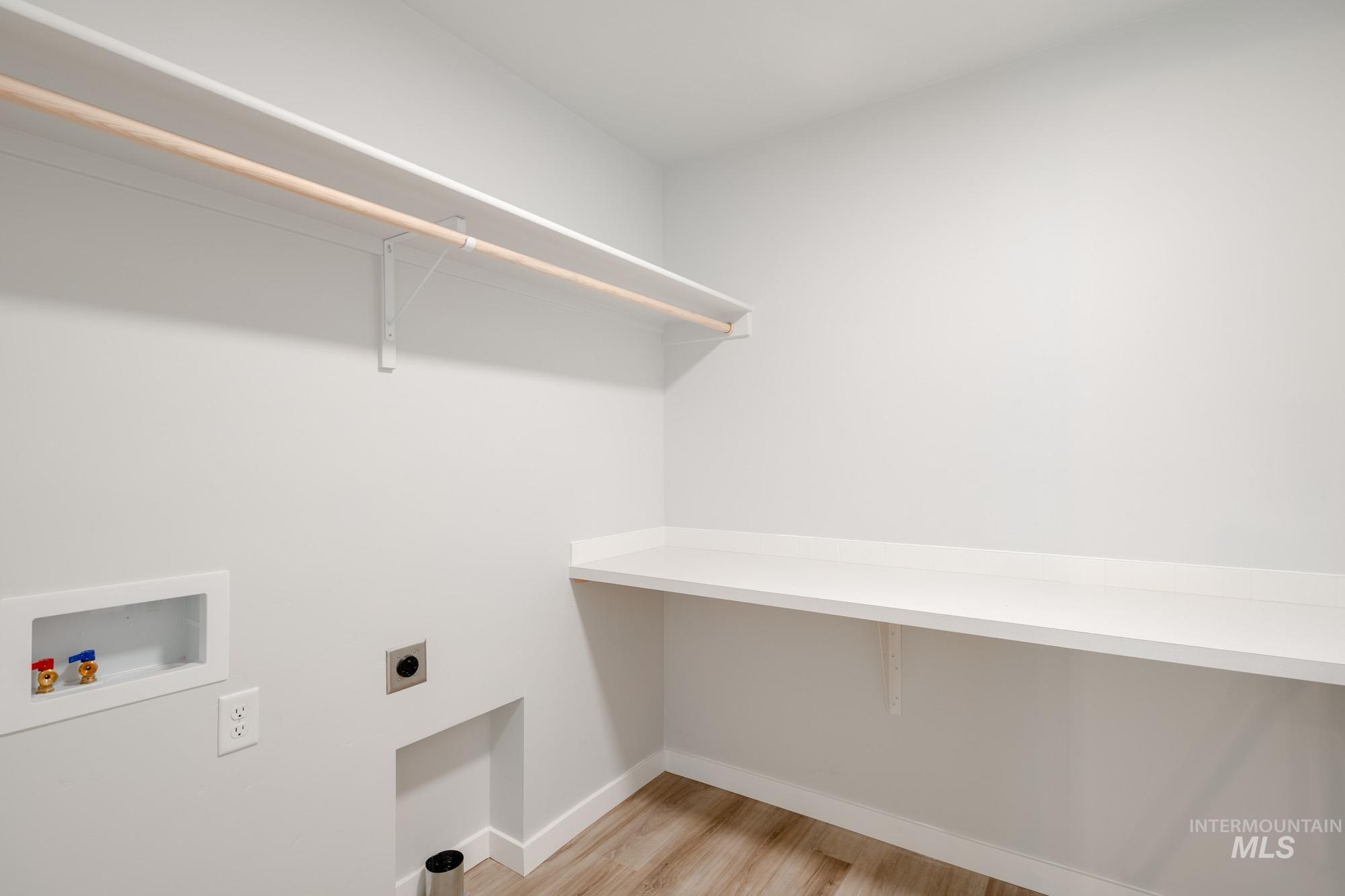 2486 West Fallon Loop Nampa, ID 83651 - Photo 15 of 18 Washroom with light wood-style flooring, hookup for a washing machine, and hookup for an electric dryer