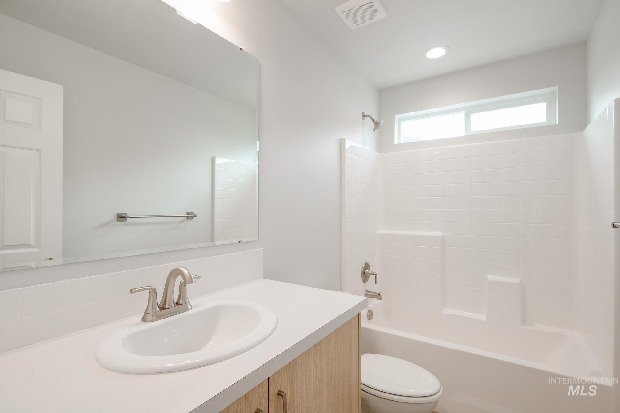 2486 West Fallon Loop Nampa, ID 83651 - Photo 16 of 18 Bathroom featuring shower combination, vanity, and backsplash