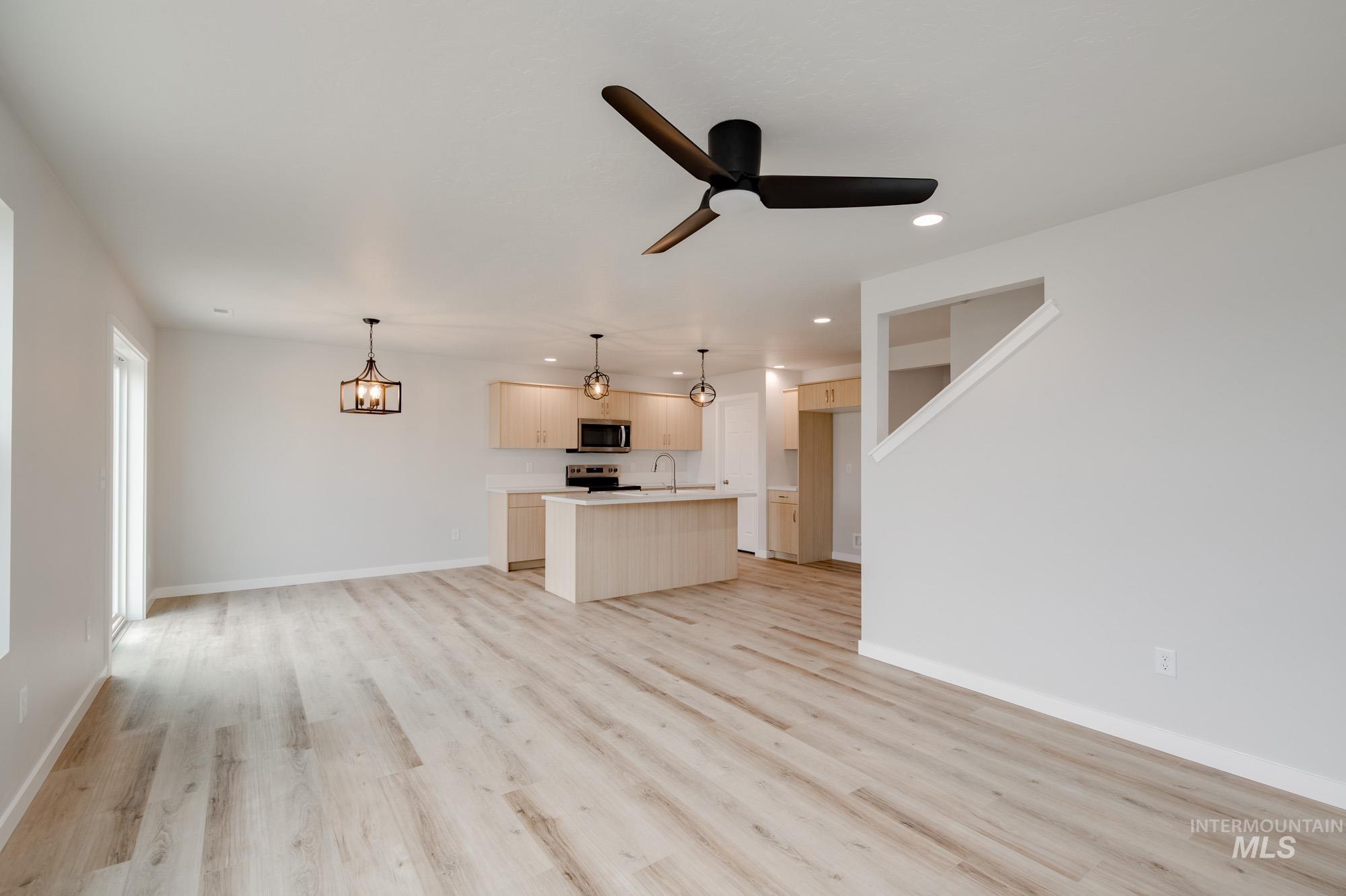 2486 West Fallon Loop Nampa, ID 83651 - Photo 6 of 18 Unfurnished living room with recessed lighting, light wood-style flooring, a ceiling fan, and a chandelier