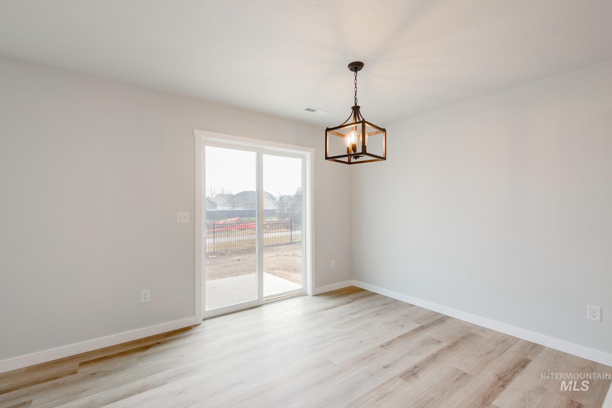 2486 West Fallon Loop Nampa, ID 83651 - Photo 8 of 18 Spare room with light wood-type flooring and a chandelier