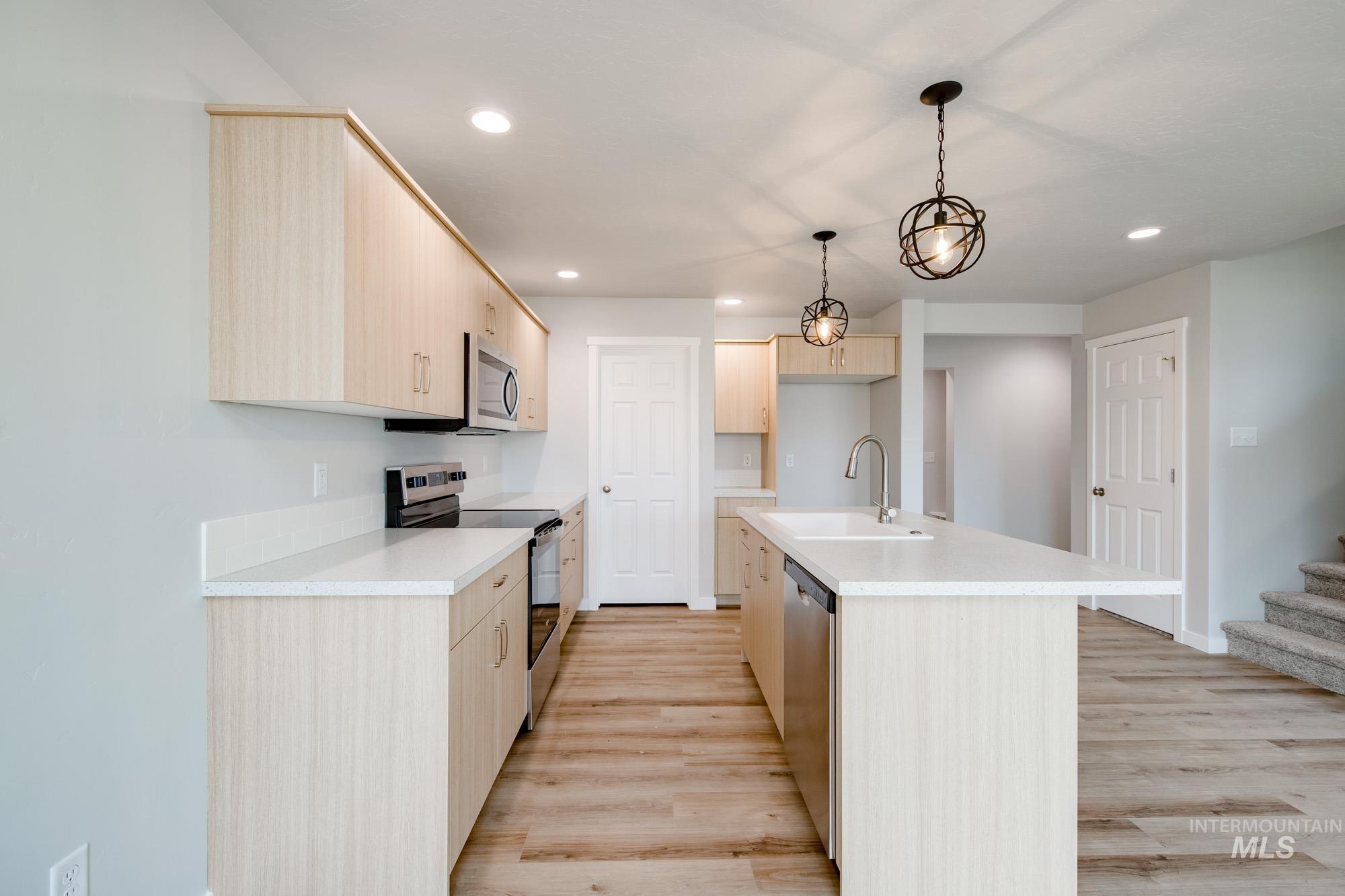 2486 West Fallon Loop Nampa, ID 83651 - Photo 9 of 18 Kitchen featuring light brown cabinetry, stainless steel appliances, light countertops, and recessed lighting