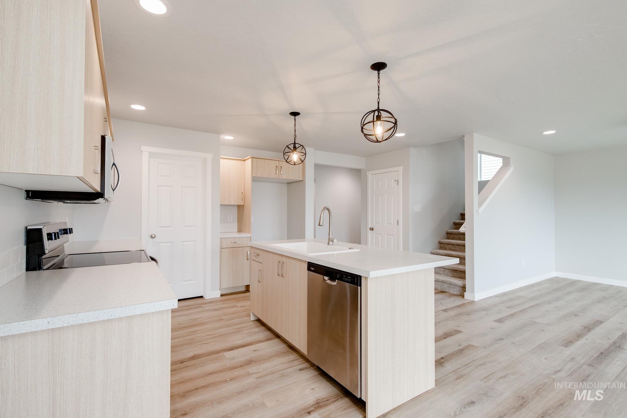 2486 West Fallon Loop Nampa, ID 83651 - Photo 10 of 18 Kitchen featuring recessed lighting, light countertops, appliances with stainless steel finishes, decorative light fixtures, and light wood-type flooring