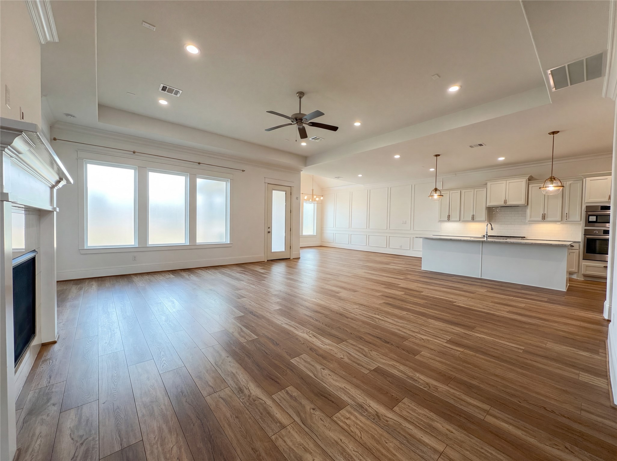 2333 Goldenglade Drive Conroe, TX 77384 - Photo 8 of 21 a view of an empty room with wooden floor and a kitchen