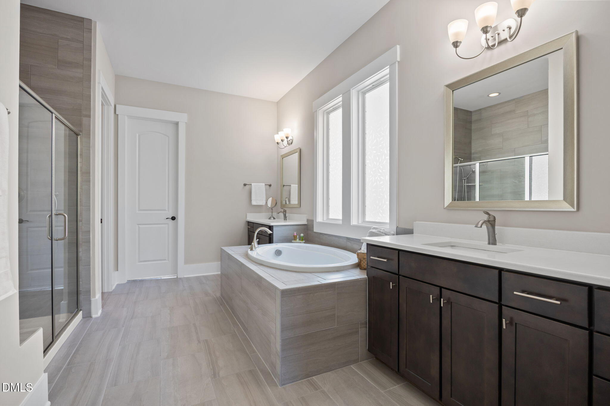 1324 Spicer Lane Rolesville, NC 27571 - Photo 20 of 59 a bathroom with a double vanity sink a mirror and a bathtub