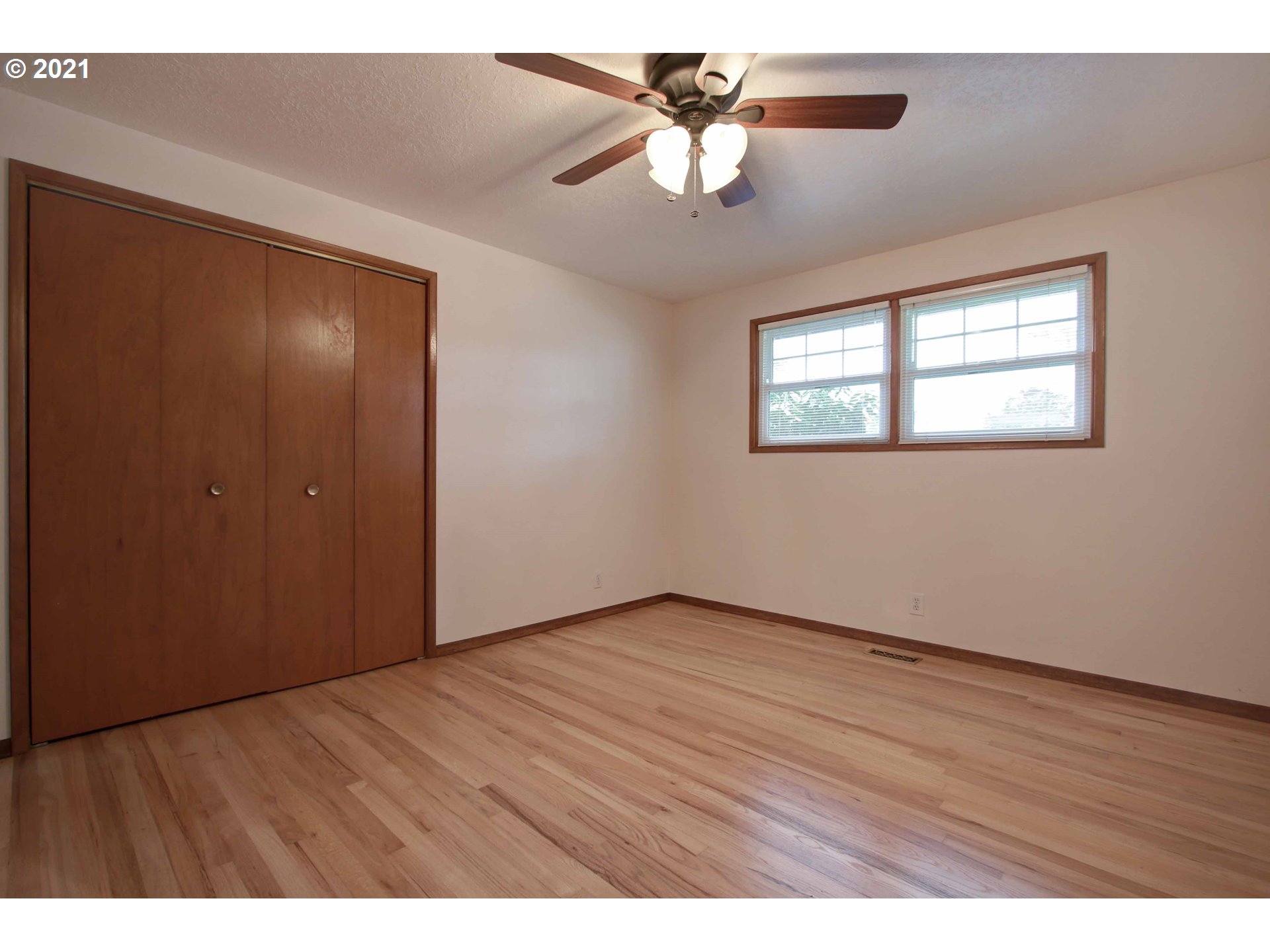 12740 Southwest Foothill Drive Portland, OR 97225 - Photo 13 of 27 an empty room with wooden floor chandelier fan and windows