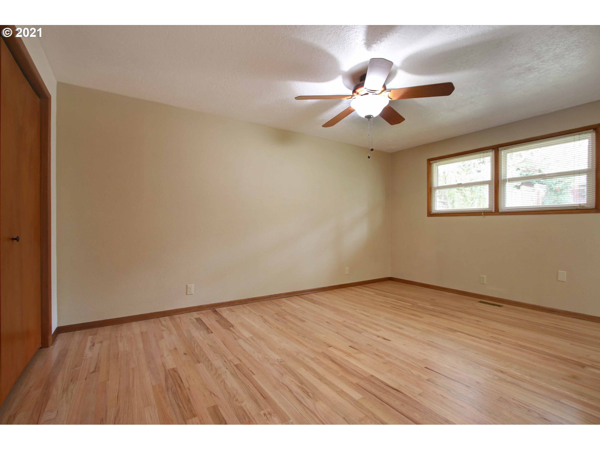 12740 Southwest Foothill Drive Portland, OR 97225 - Photo 17 of 27 an empty room with wooden floor fan and windows