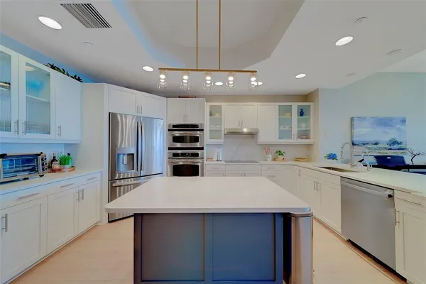 a kitchen with stainless steel appliances white cabinets and a refrigerator