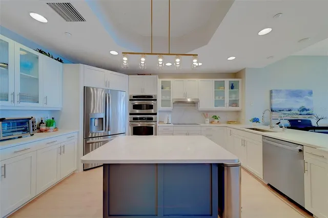 a kitchen with stainless steel appliances white cabinets and a refrigerator