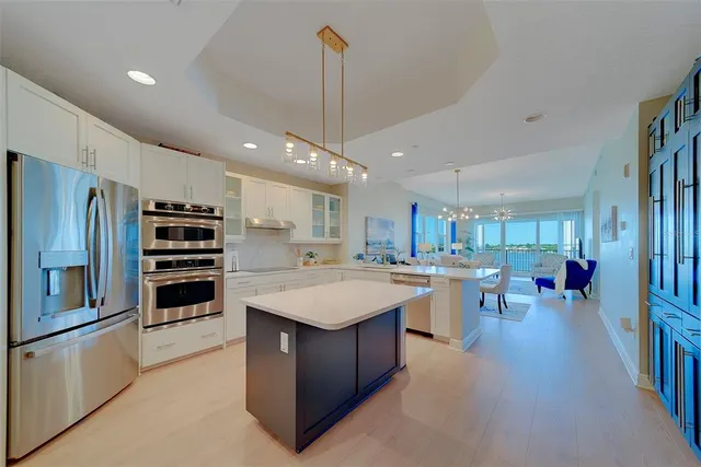 a large white kitchen with a large counter top appliances and cabinets