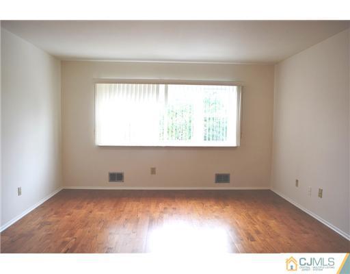 7103 Hana Road Edison, NJ 08817 - Photo 3 of 7 an empty room with wooden floor and windows
