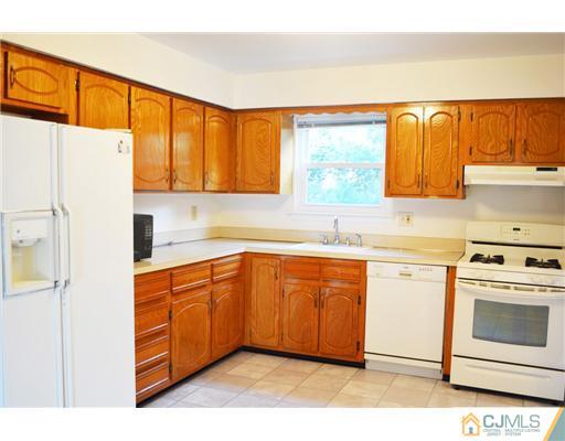 7103 Hana Road Edison, NJ 08817 - Photo 4 of 7 a kitchen with stainless steel appliances granite countertop a stove a sink and a refrigerator with wooden floors