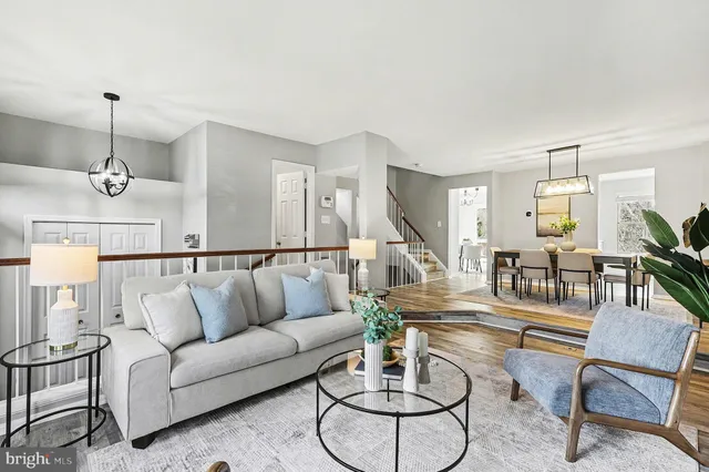 a living room with furniture kitchen view and a wooden floor