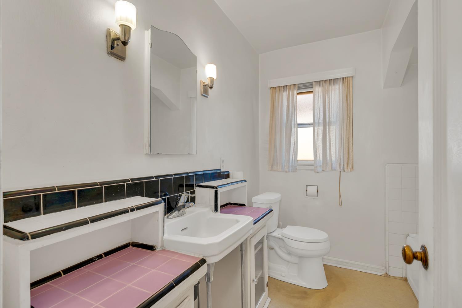 500 North G Street Madera, CA 93637 - Photo 18 of 24 a bathroom with a sink a toilet and a mirror