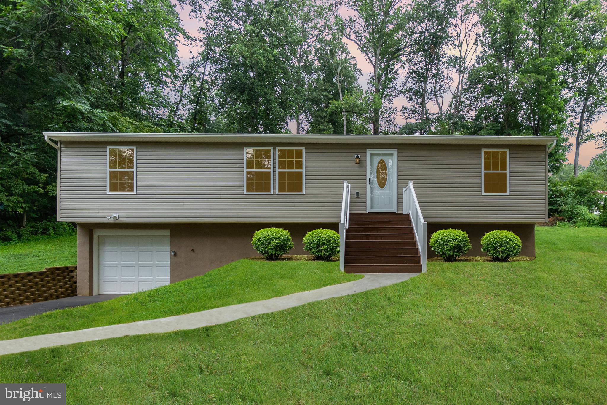 a front view of a house with garden and plants