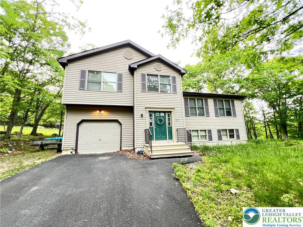 107 Warbler Court Bushkill, PA 18324 - Photo 2 of 32 a front view of a house with a yard and garage
