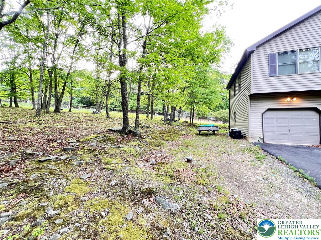 107 Warbler Court Bushkill, PA 18324 - Photo 3 of 32 a view of a backyard with large trees