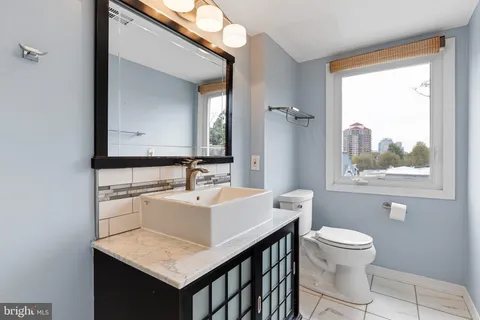 a bathroom with a sink a toilet and a mirror