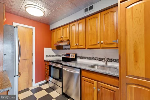 a kitchen with stainless steel appliances a stove a sink and a refrigerator