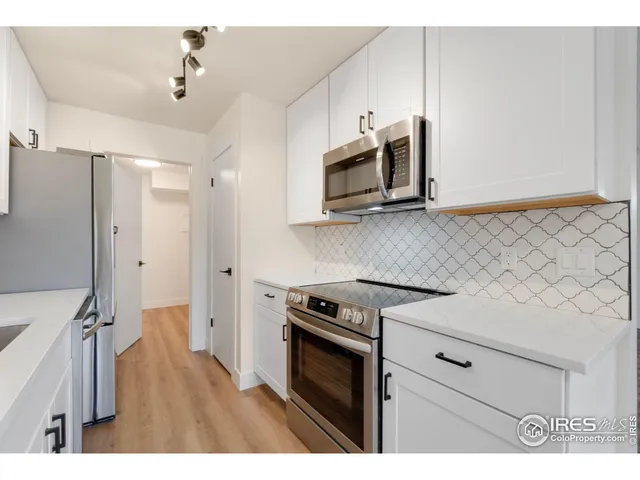 a kitchen with stainless steel appliances white cabinets and a stove