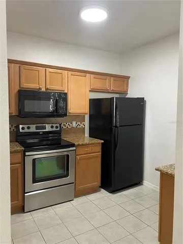 a kitchen with a refrigerator and a stove top oven