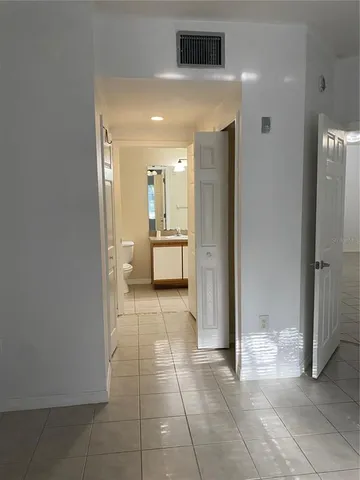 a view of a hallway with bathroom and a shower