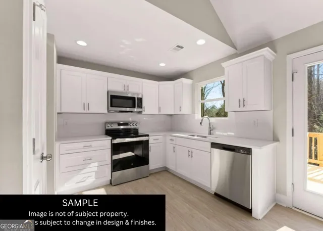 a kitchen with granite countertop stainless steel appliances and white cabinets