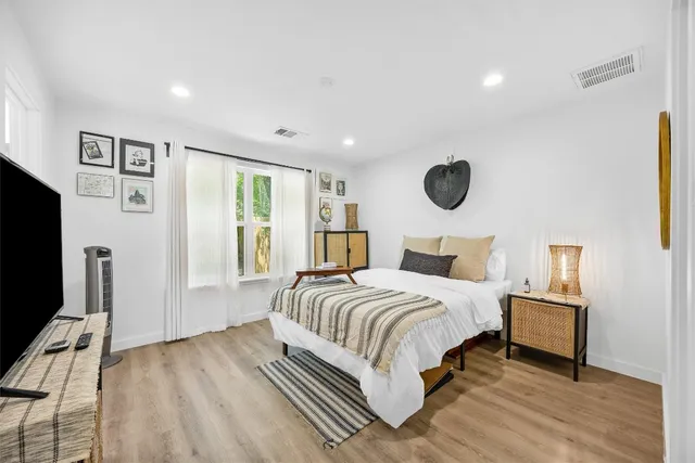 a bedroom with a bed and wooden floor