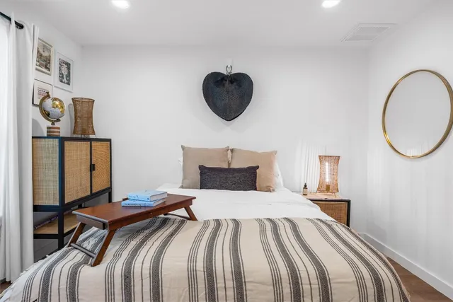 a bedroom with a bed and a painting on the wall